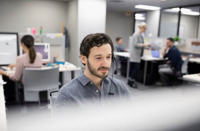 Man in office using headset at desk